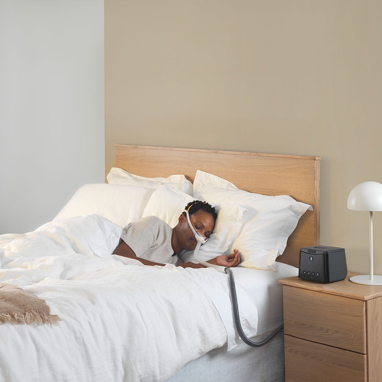 A woman laying on her side sleeping with the F&P Solo Mask